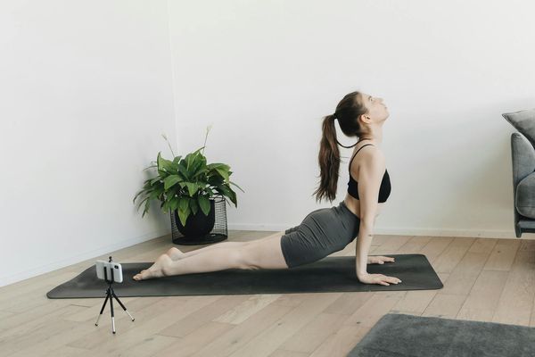 Minimalist workspace with a yoga mat and green plant.
