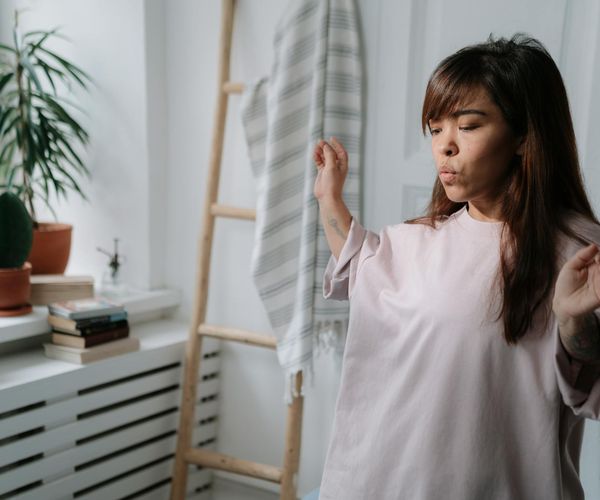 Serene person meditating in a minimalist pearl colored room.